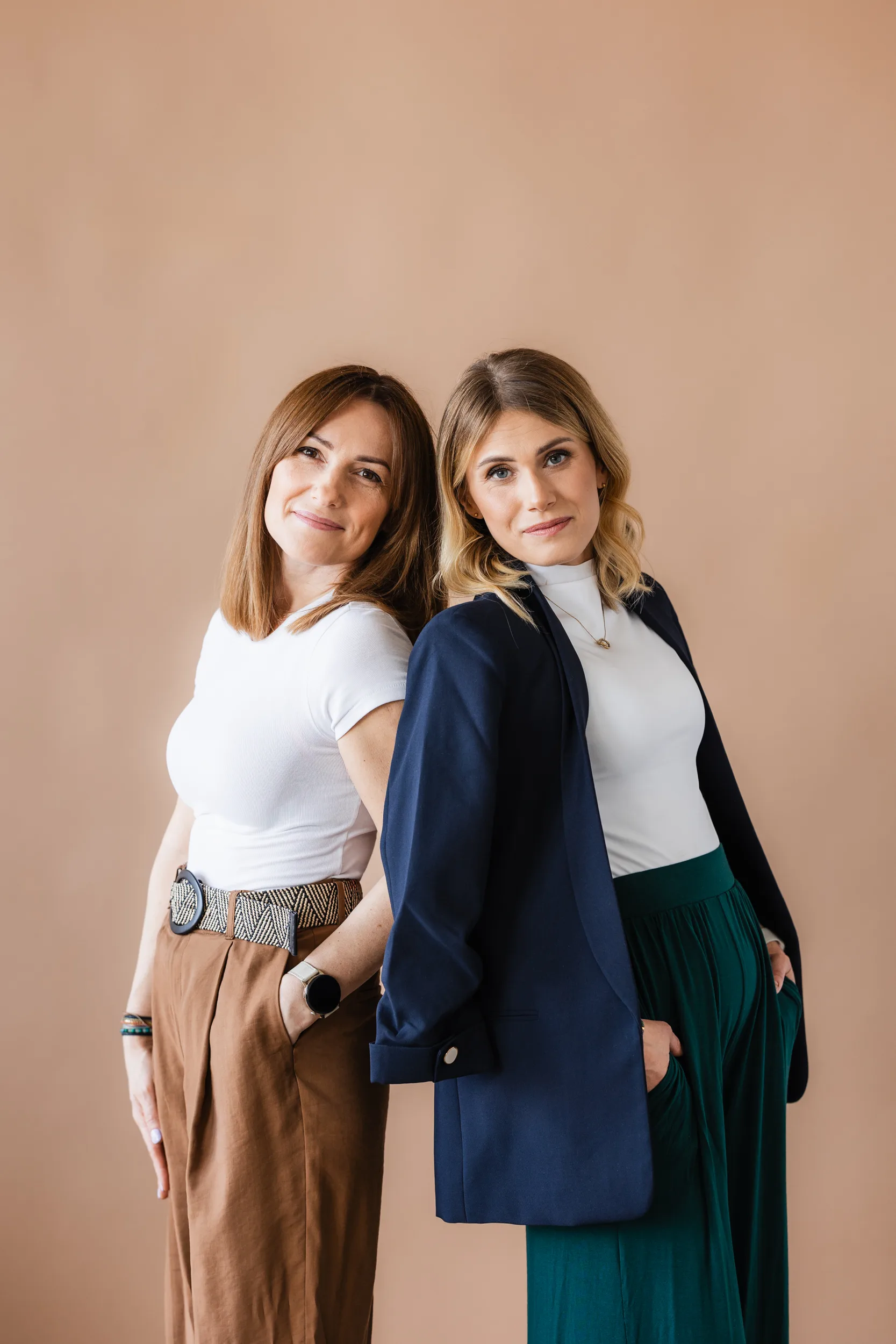 Założycielki Fundacji Mindset, Anna Karcz-Czajkowska i Karolina Gruszczyńska, opierają się o siebie plecami i uśmiechają do kamery